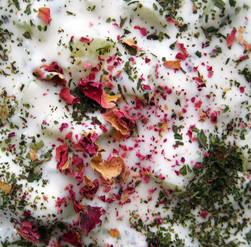 cucumber yogurt sprinkled with rose petals and dried mint close up shot